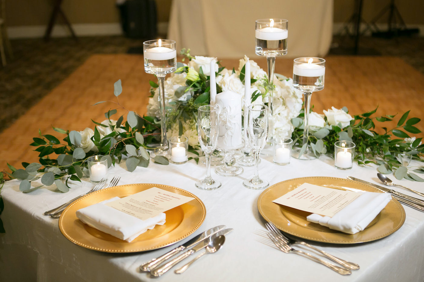 Tampa Classic Timeless Wedding Reception Decor, Sweetheart Table with White Linen, Gold Chargers, Floating Candlesticks , Eucalyptus Greenery and White Florals | Wedding Photographer Carrie Wildes Photography