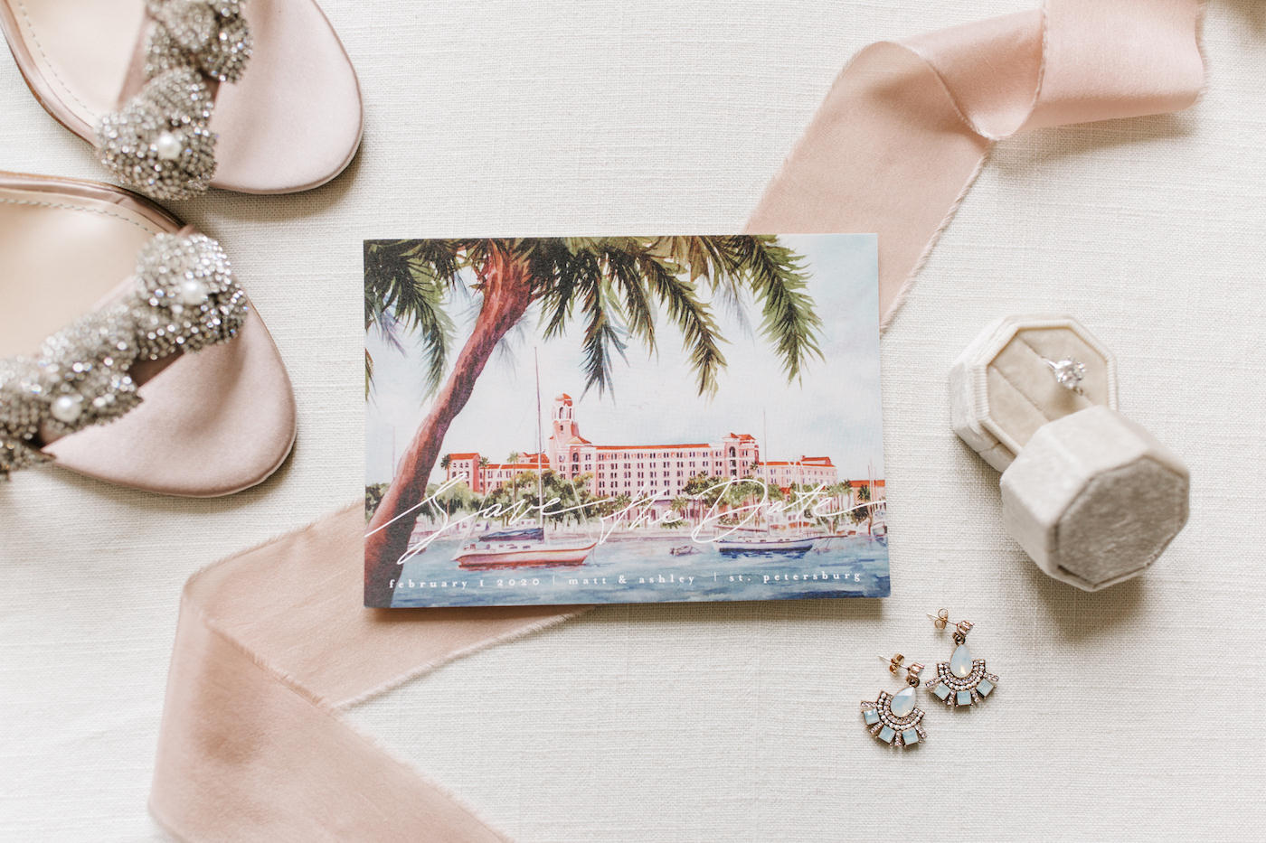 Luxury Florida Save the Date, Watercolor Portrait of Waterfront Vinoy Renaissance Resort in Downtown St. Petersburg, Bridal Wedding Accessores, Diamond Solitaire Engagement Ring in Cream Velvet Ring Box, Teal Boho Chic Earrings, Crystal Floral Strappy Sandal Wedding Shoes | Tampa Bay Wedding Planner Parties A’ La Carte