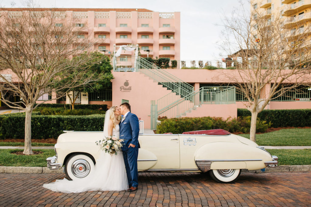 Florida Bride and Groom Wedding Portrait in Front of Vintage White Car | Ashley Stegbauer Morrison Wearing Boho Chic Inspired Ines Di Santo Wedding Dress| Tampa Bay Historic Wedding Venue The Vinoy Renaissance Resort | Downtown St. Pete Wedding Planner Parties A’ La Carte | Wedding Dress Shop Isabel O’Neil Bridal Collection