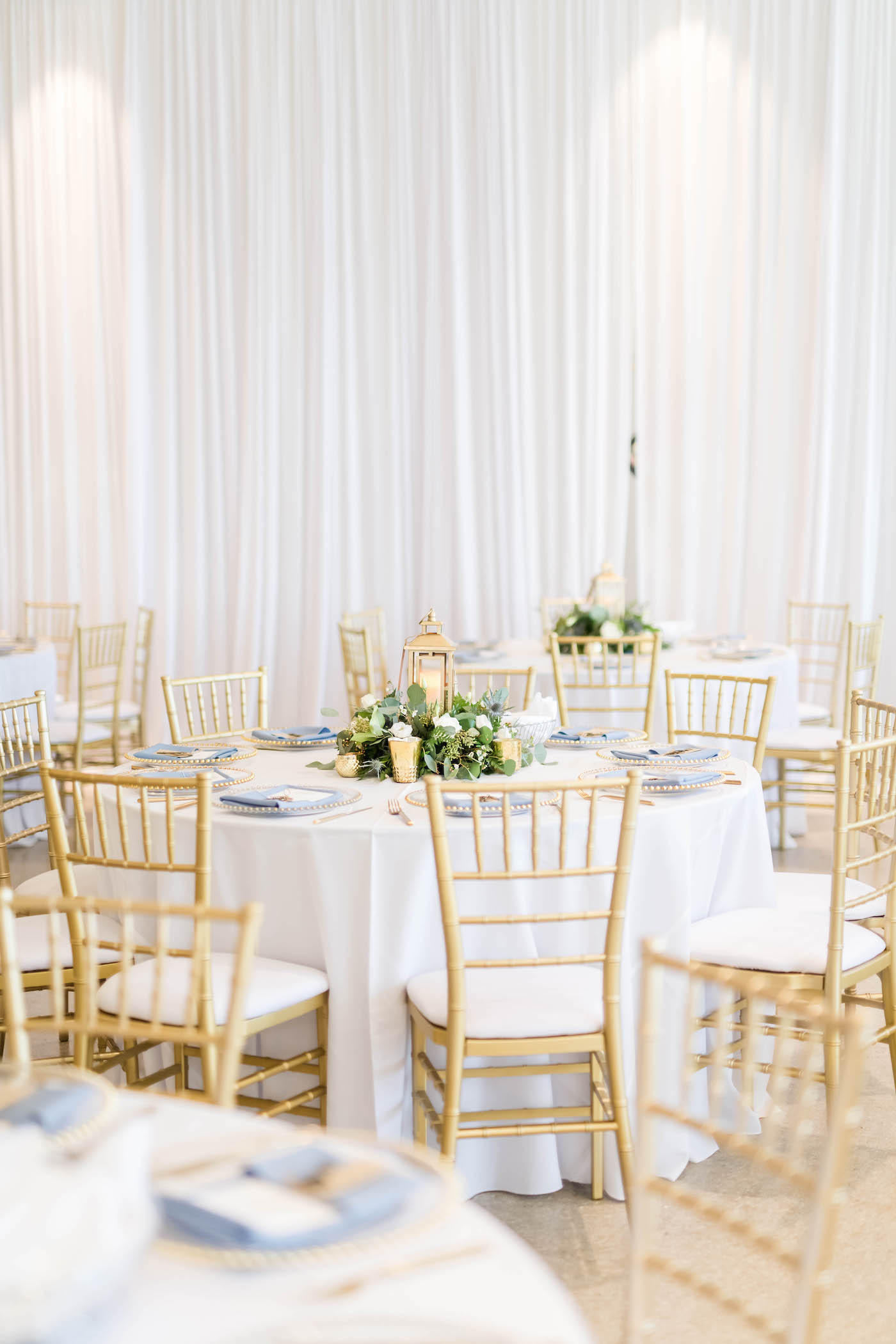 Tampa Wedding Venue the Tampa Garden Club Indoor Reception | Wedding Reception Tables with White Linens and Gold Chiavari Chairs and Low Greenery and Lantern Centerpieces | Gabro Event Services | Lynn's Catering of Tampa