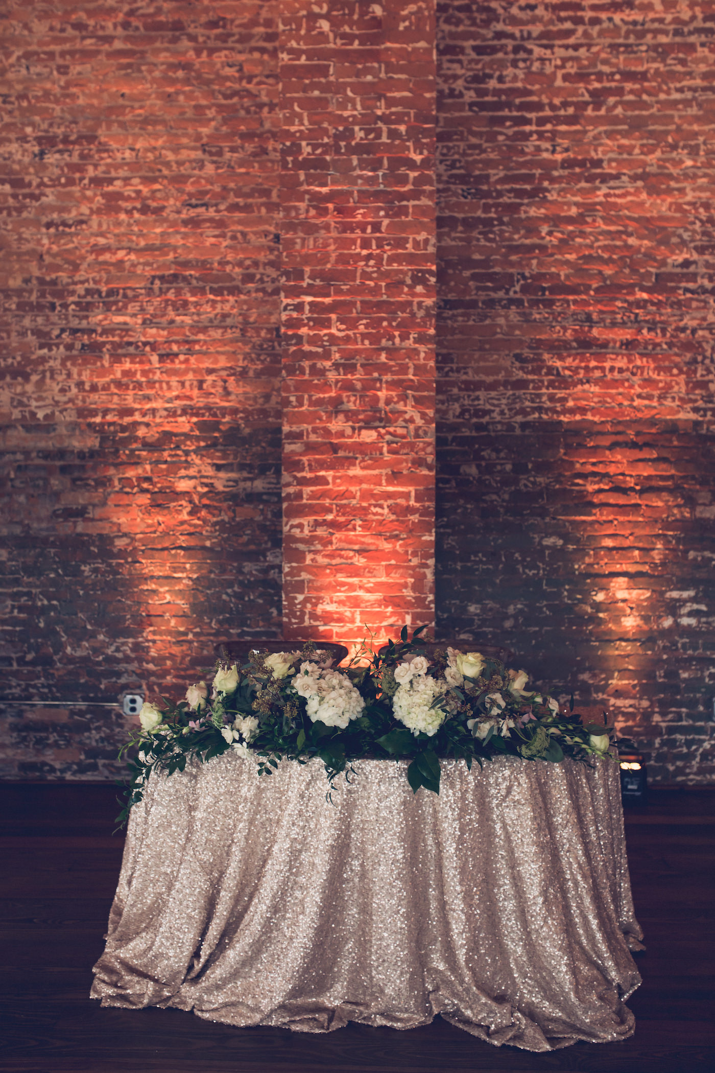 Tampa Wedding Sweetheart Table with Blush Rose Gold Sequin Linen and Greenery Floral Garland and Amber Uplighting
