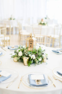 Wedding Centerpiece with Lantern and Greenery with Gold Votive Candles and Kraft Paper Table Number Tag | Dusty Blue and White and Gold Wedding