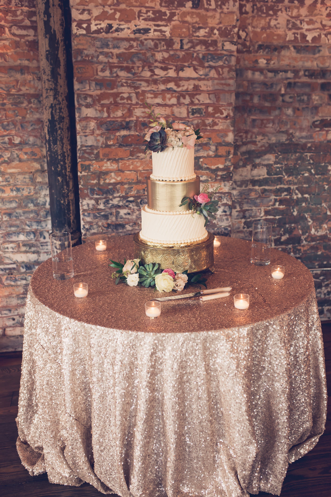 Wedding Cake Table with Champagne Rose Gold Sequin Linen and Votive Candles | Three Tier Gold and Ivory Wedding Cake with Fresh Flowers on Round Ornate Gold Cake Stand | Tampa Wedding Bakery The Artistic Whisk