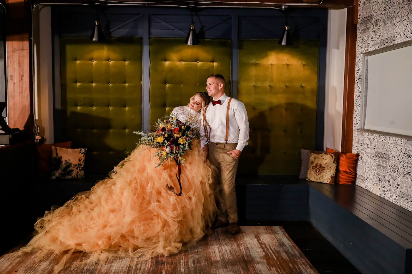 Florida Bride and Groom Wedding Portrait, Vintage Inspired Decor and Attire, Bride in Long Oversized Blush Orange Tulle Skirt with Long Sleeve Lace Blouse, Holding Bohemian Inspired Floral Bouquet with Yellow, Deep Red, Purple, Eggplant and Peach Flowers, with Greenery and Pampas Grass, Groom in Neutral Brown Suit with Suspenders and Velvet Bowtie | Downtown St. Petersburg Wedding Planner Blue Skies Weddings and Events | Florida Wedding Photographer Lifelong Photography Studio | Tampa Bay Unique Wedding Venue Station House in DTSP