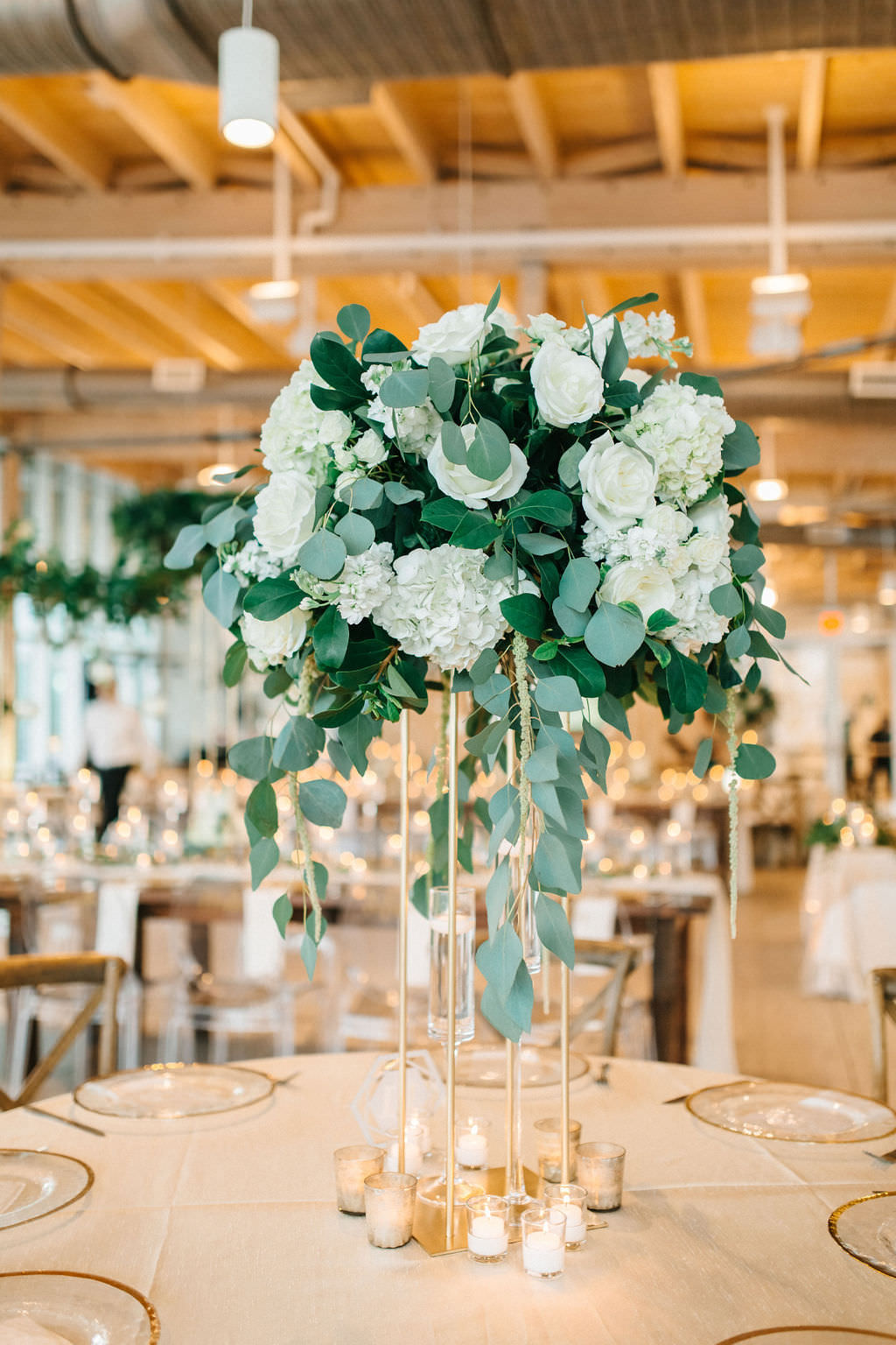 Modern, Elegant Florida Wedding Decor and Reception, Tall Floral Centerpiece with White Roses and Ivory Florals, and Greenery, Gold Geometric Accents, Clear Chargers, Round Tables with Linens | Tampa Bay Wedding Planner UNIQUE Weddings and Events | Florida Special Event Rental Company Over The Top Linens | Tampa Decor Rental A Chair Affair