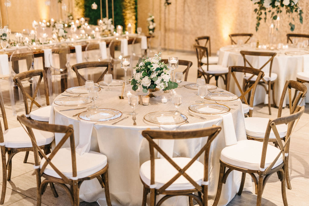 Elegant Florida Wedding Reception and Decor, Wooden Crossback Chairs and Round Tables with Ivory Linens, Clear Chargers, Candlelight Votives, Low Floral Centerpiece with White Roses and Greenery | Florida Wedding Planner UNIQUE Weddings and Events | Over The Top Linen Rentals | A Chair Affair