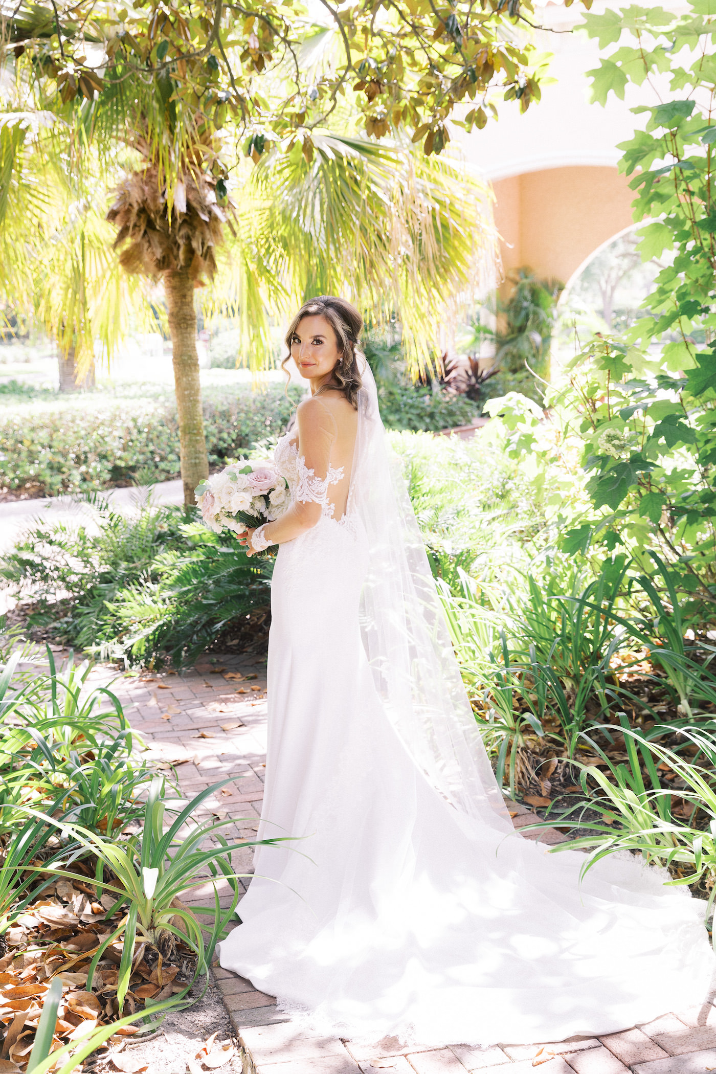 Ines di Santo Designer Bridal Gown Illusion Lace Sexy Wedding Dress | Outdoor Bridal Portrait at Tampa Wedding Venue Avila Golf & Country Club | White and Blush Pink Round Rose Bridal Bouquet | Isabel O'Neil Bridal Collection | Tampa Wedding Hair and Makeup Femme Akoi Beauty Studio