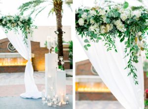 Elegant Classic Wedding Ceremony Decor, White Draped Arch with Greenery and White Roses and Hydrangeas, White Pedestals with Floating Candle Vases, Red Brick Fireplace Backdrop | Wedding Photographer Shauna and Jordon Photography | Tampa Wedding Planner UNIQUE Weddings + Events |
