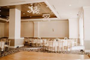 Clearwater Wedding Venue Hyatt Regency Clearwater Beach Hotel | Ballroom Reception with White Table Linens and Gold Chiavari Chairs and Wood Dance Floor with Glass Bubble Chandeliers