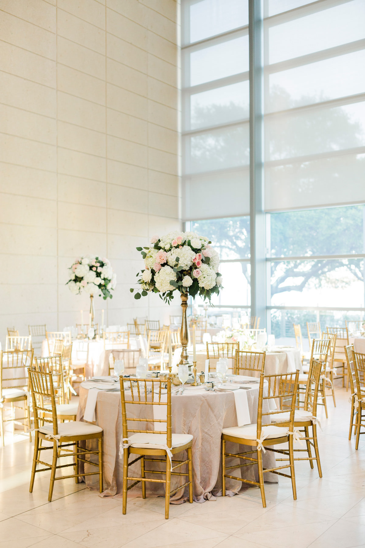 St. Pete Wedding Venue Museum of Fine Arts | Indoor Wedding Reception with Gold Chiavari Chairs and Tall Gold Candlestick Centerpieces with White Hydrangea and Blush Pink Roses and Eucalyptus Greenery | Bruce Wayne Florals