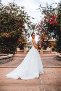 Bride Portrait at St. Pete Wedding Venue The Poynter Institute | White Embroidered Organza Ballgown Illusion Neck Bib Neckline Bridal Gown with Open Back | Red and Pink Bridal Bouquet | Tampa Wedding Dress Shop Truly Forever Bridal