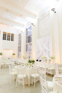 Elegant Classic Wedding Reception and Decor, White Criss Cross Draping and Custom Monogram Gobo Light as Backdrop for Sweetheart Table, Lush Greenery, Ivory Linens, Tall Candelabra Centerpieces with Greenery and Flowers, White Chiavari Chairs | Downtown Tampa Wedding Venue The Vault | Florida Wedding Planner Breezin' Weddings