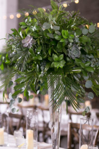 Wes Anderson Inspired Wedding Reception Decor, Tall Glass Vase with Palm Fronds, Succulents, Eucalyptus Greenery Centerpiece | Wedding Photographer Carrie Wildes Photography | Tampa Bay Wedding Venue The Rialto Theatre | Wedding Planner UNIQUE Weddings and Events | Wedding Florist Monarch Events and Design