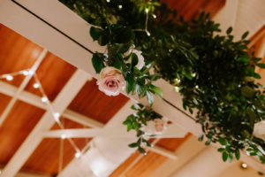 Wedding Ceiling Floral Installment with Greenery and Blush Pink and White Roses and Canopy String Lights