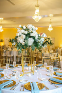 Classic Elegant Wedding Reception Decor, Tall Modern Geometric Gold Stand with Lush White Hydrangeas, Roses and Greenery, Eucalyptus Centerpiece, Gold Chargers with Dusty Blue Linen Napkins | Tampa Bay Wedding Photographer Kera Photography | Wedding Rentals Outside the Box Rentals | Wedding Planner Breezin' Weddings | Historic Wedding Venue The Orlo