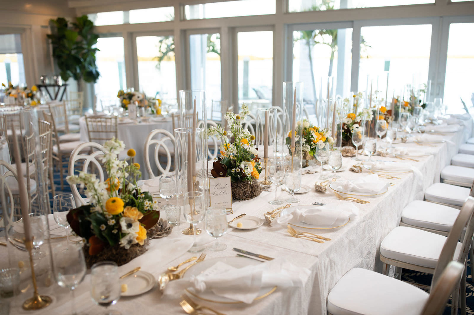 Elegant Nautical Wedding Reception Decor, Long Feasting Table with White Linens, Gold Flatware, Gold Candlesticks, Yellow, White and Greenery Low Floral Centerpieces | Tampa Bay Wedding Planner Parties A'la Carte | Clearwater Wedding Venue Carlouel Yacht Club