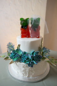 Two Tier White Wedding Cake with Succulent Sugar Flowers and Red and Green Bride and Groom Gummy Bear Cake Topper | Wedding Photographer Carrie Wildes Photography | Tampa Wedding Planner UNIQUE Weddings and Events