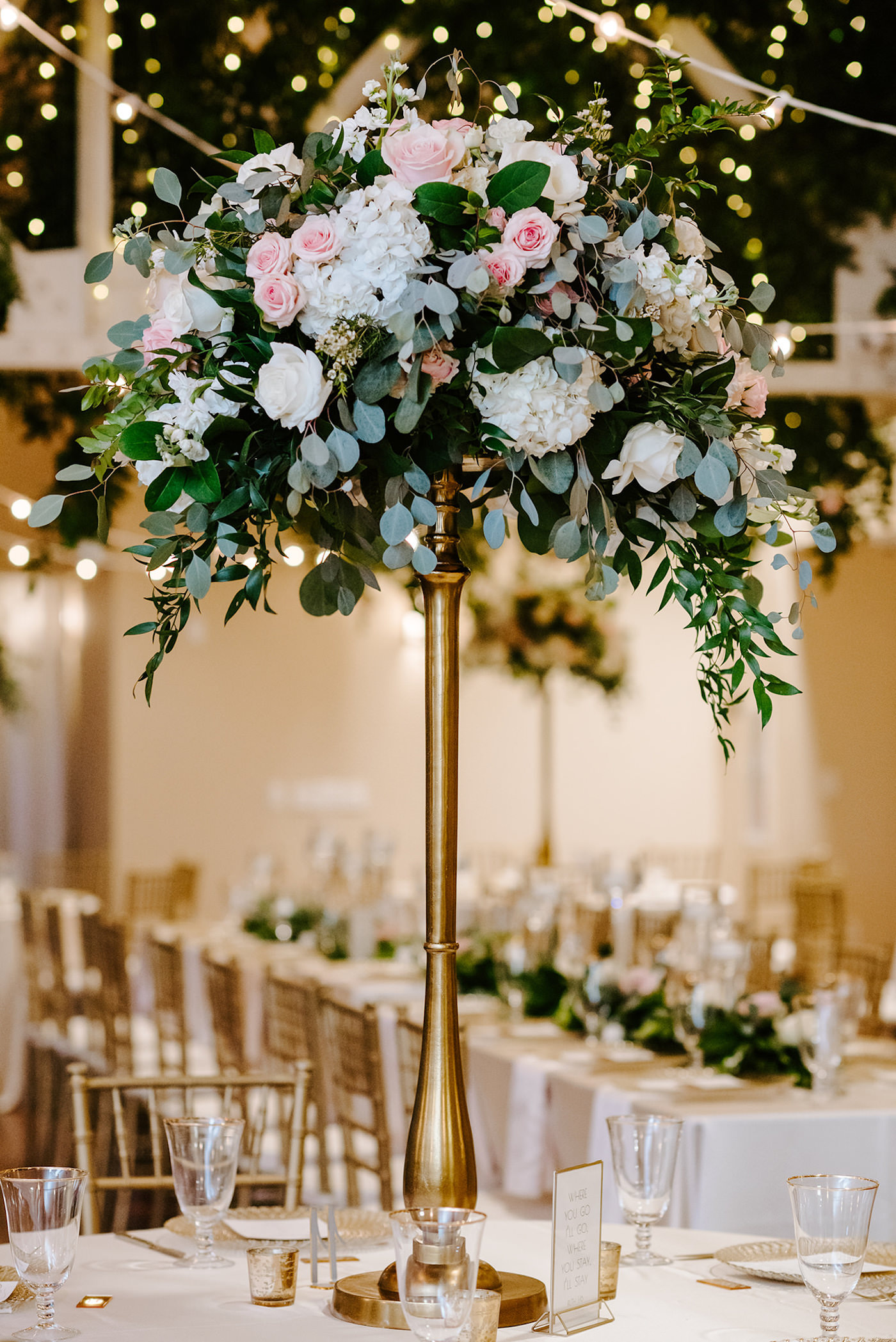 Tall Wedding Centerpiece with White Hydrangea and Blush Pink Roses and Eucalyptus Greenery on top of Gold Candlestick | Monarch Events and Design