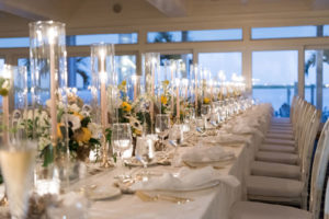 Elegant Nautical Wedding Reception Decor, Long Feasting Table with White Linens, Gold Flatware, Gold Candlesticks, Yellow, White and Greenery Low Floral Centerpieces | Tampa Bay Wedding Planner Parties A'la Carte | Clearwater Wedding Venue Carlouel Yacht Club