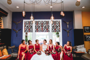 Bride and Bridesmaids Hotel Lobby Portraits | Mismatched Deep Red Maroon Berry Azazie Bridesmaid Dresses with Red and Pink Bouquets