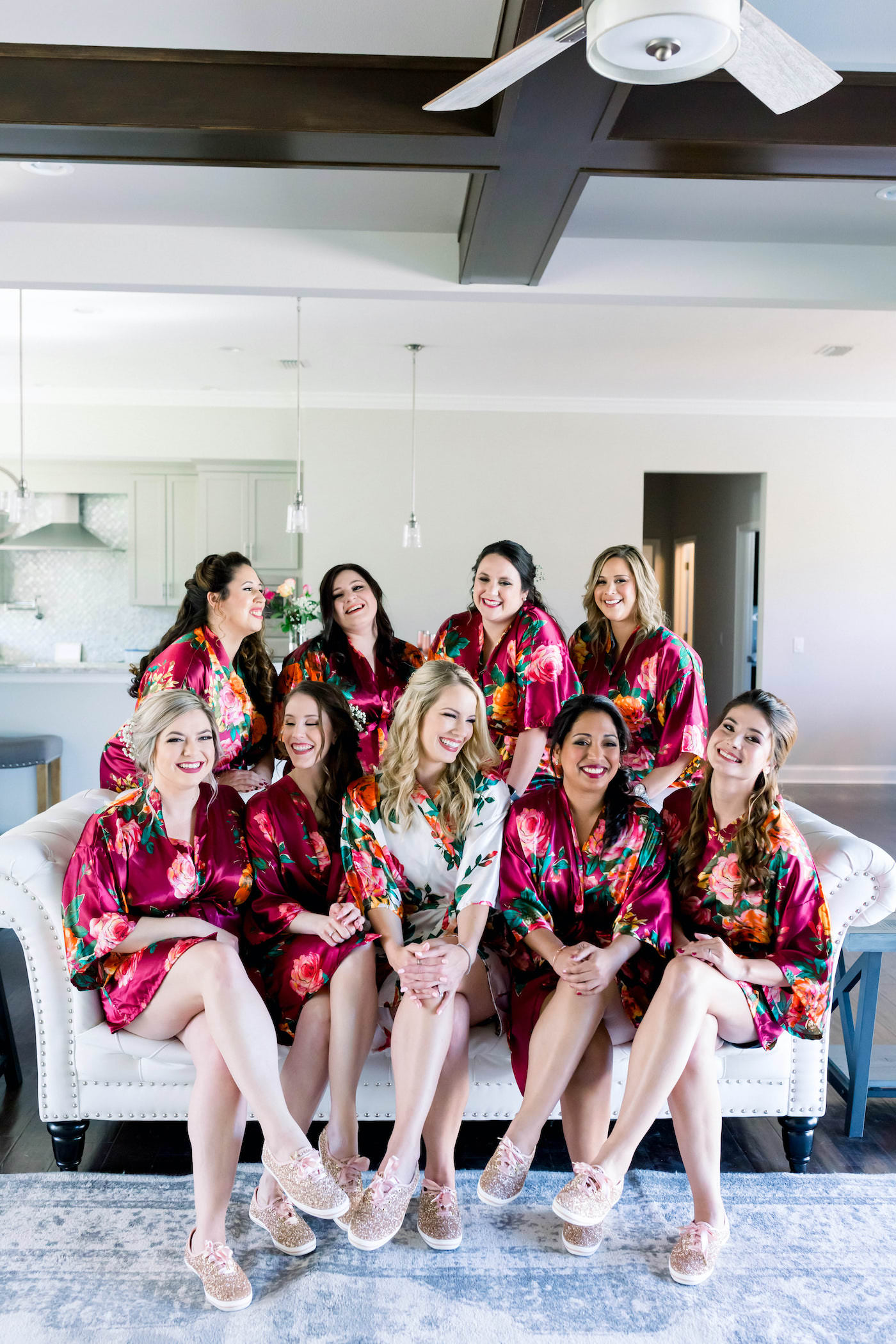 Bride and Bridesmaids Getting Ready in Burgundy Silk Floral Robes and Gold Glitter Kate Spade Tennis Shoes | Shauna and Jordon Photography