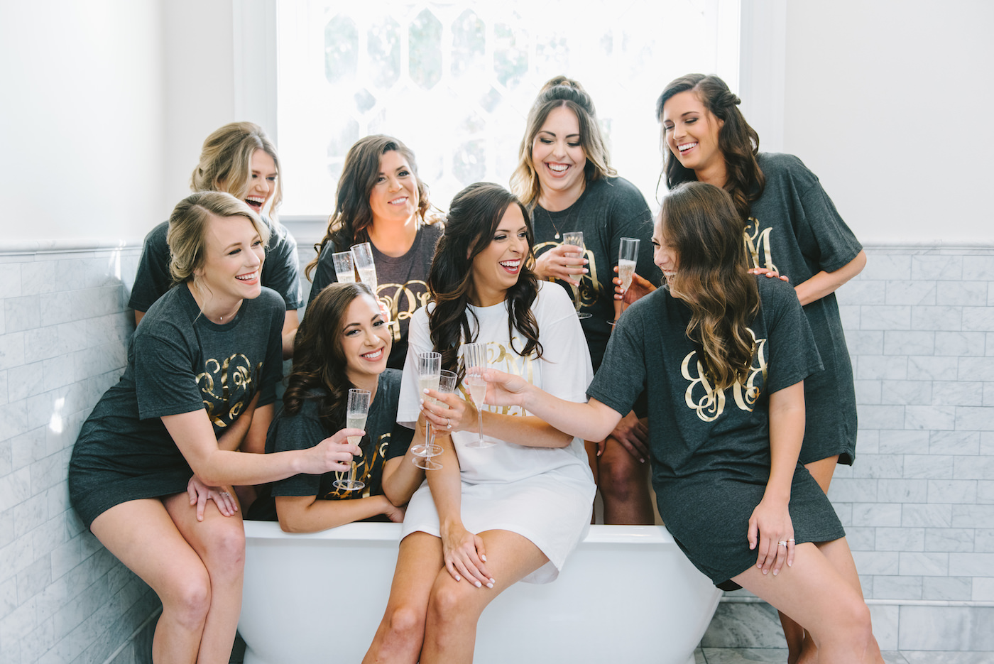 Classic Bride and Bridesmaids in Dark Gray Pajama Tees with Personal Gold Foil Monograms Cheering with Champagne Flutes | Tampa Bay Wedding Photographer Kera Photography