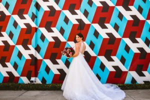 Bride Mural Portrait St. Pete Wedding | White Embroidered Organza Ballgown Illusion Neck Bib Neckline Bridal Gown with Open Back | Red and Pink Bridal Bouquet | Tampa Wedding Dress Shop Truly Forever Bridal