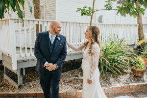 Ybor City Tampa Wedding Bride and Groom Outdoor First Look | Long Sleeve Lace Bridal Gown Wedding Dress | Classic Navy Blue Groom Suit