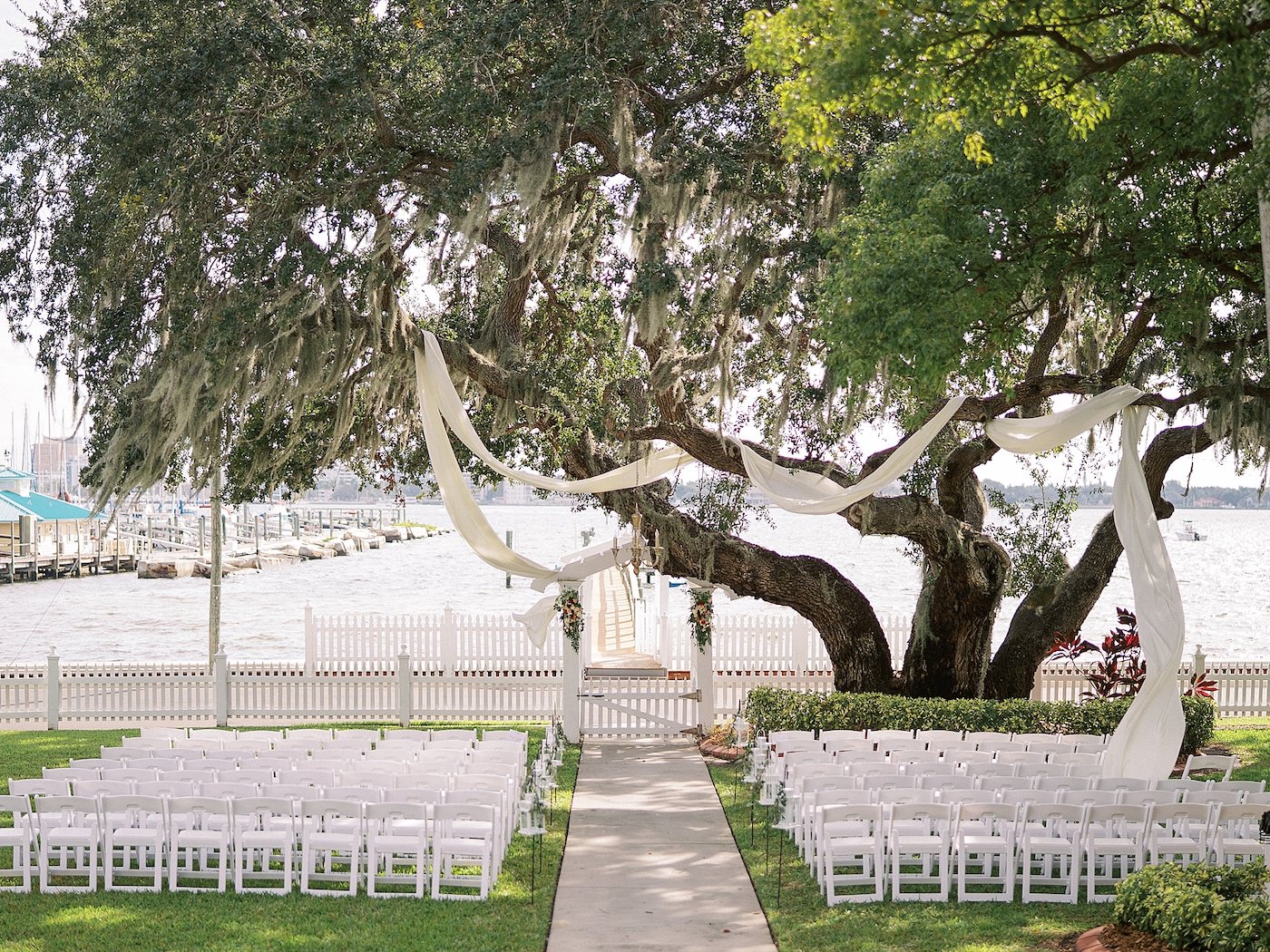 Wedding Ceremony Tree Fabric Swag by Tampa Wedding Florist Brides N Blooms | Florida Fall Autumn Wedding Waterfront Venue with White Garden Chairs