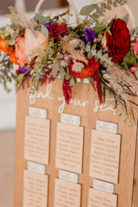 Boho Glam Wedding Inspiration | Etched Wood Seating Chart Unique Table Plan Alternative | Jewel Tone Floral Arrangement with Roses, Eucalyptus and Pampas Grass