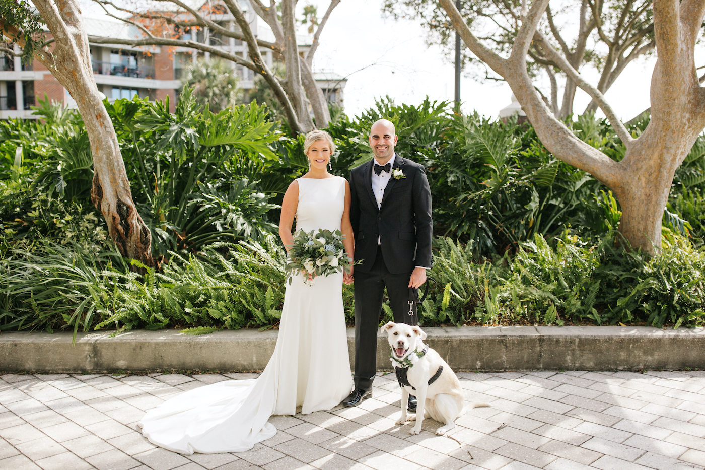 Bride and Groom and Dog of Honor Outdoor Portrait | Simple Sheath Ivory Crepe Bateau Neck Bridal Gown by Theia | Groom in Classic Black Tux Suit with Bow Tie | FairyTail Pet Care