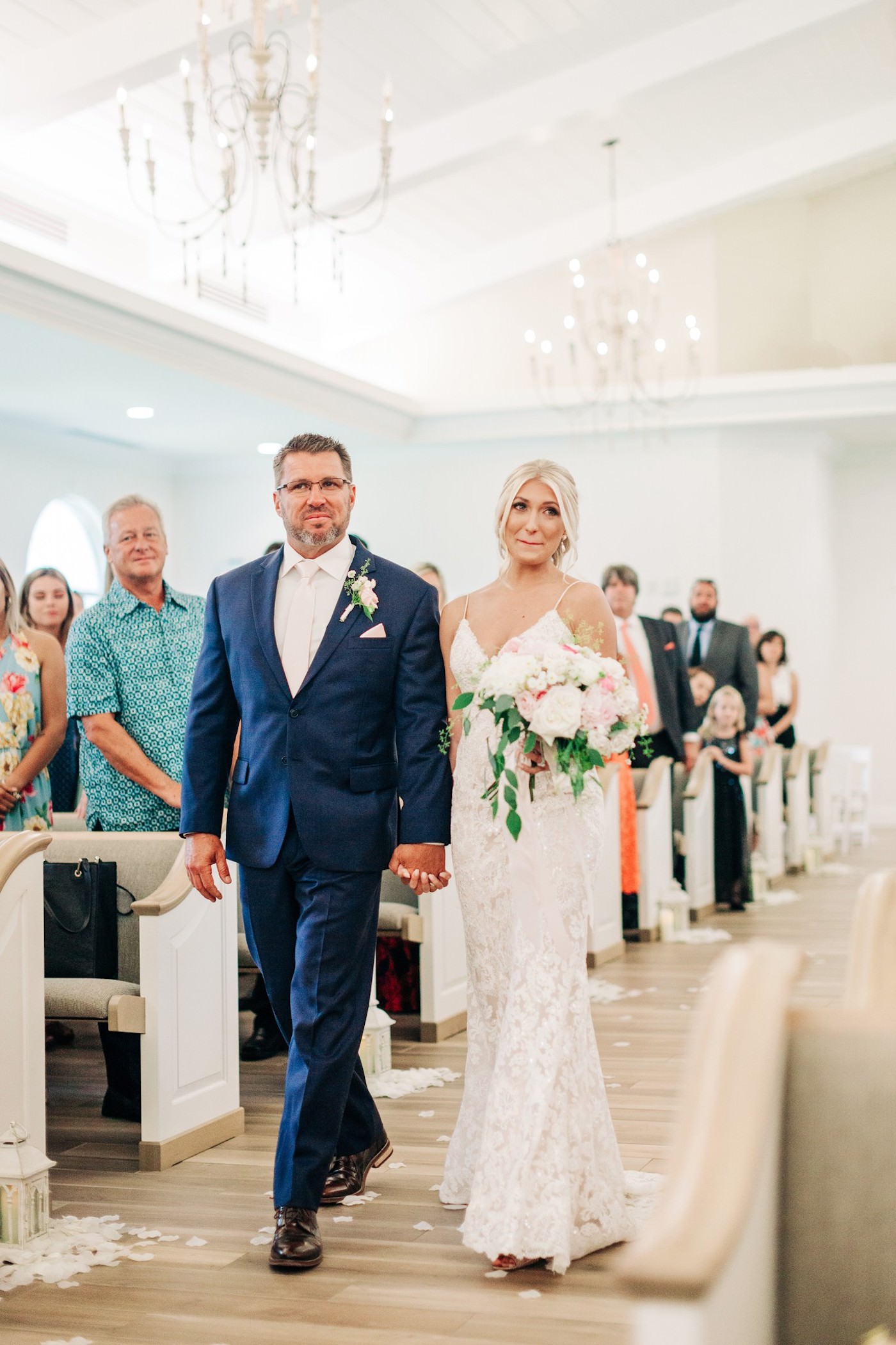 Bride and Dad Walking Down the Aisle at Safety Harbor Wedding Ceremony Venue Harborside Chapel | Father of the Bride in Navy Blue Suit | Ivory and Champagne Lace Wedding Gown