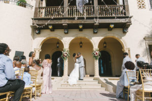 Florida Bride and Groom Kiss in Courtyard Wedding Ceremony at Historic Powel Crosley Estate | Tampa Bay Destination Wedding Planner Special Moments Event Planning | Gold Chiavari Chair Rentals Gabro Event Services | Florida Wedding Photographer Kera Photography