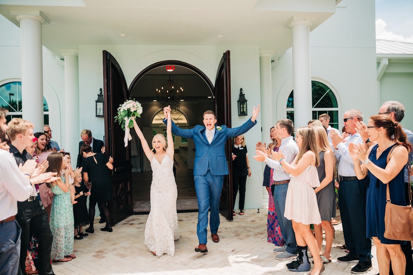 Bride and Groom Ceremony Exit at St. Petersburg Wedding Venue Harborside Chapel | Groom in Navy Blue Suit | Ivory and Champagne Lace Bridal Gown Wedding Dress