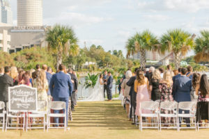 Downtown Tampa Riverwalk Wedding Venue | Outdoor Wedding Ceremony with White Chairs and Chalkboard Wedding Sign overlooking Hillsborough River