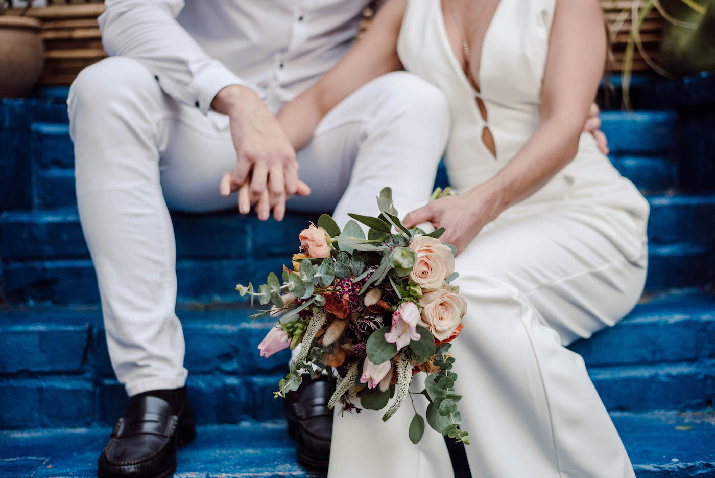 Bride and Groom Outdoor Wedding Portrait | COVID Wedding Elopement Backyard Ceremony | Ivory White Bridal Jumpsuit | Casual Groom White Shirt and Pants | DIY Peach and Pink Bridal Bouquet with Roses Tulips and Eucalyptus Greenery