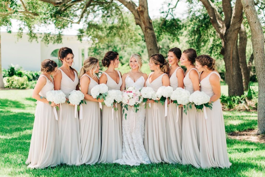 Outdoor Garden Tampa Wedding Bridal Party Portrait | Neutral Nude Champagne Watters Bridesmaid Dresses from Bella Bridesmaid | White Hydrangea Bouquets with Cascading Ribbon | Champagne and Ivory Lace Sheath Spaghetti Strap Wedding Dress Bridal Gown with White and Blush Pink Bouquet | Femme Akoi Beauty Studio