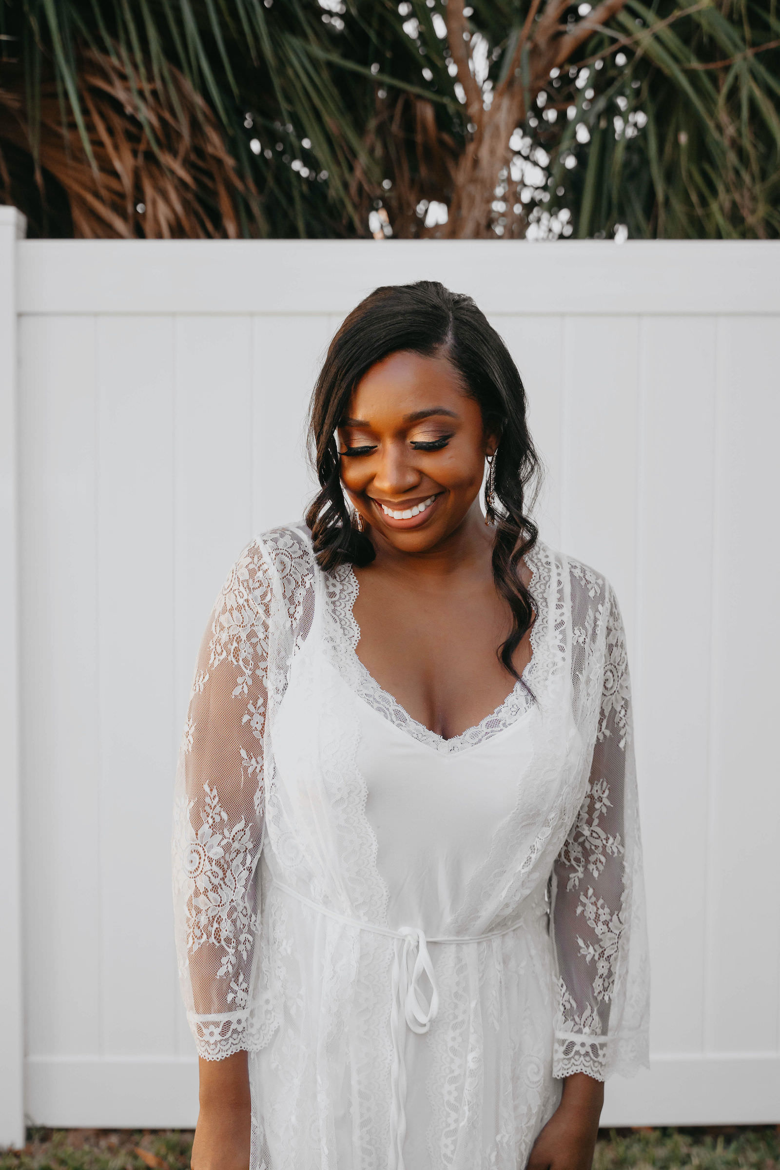 Tampa Bride Getting Ready Wearing White Lace Robe | Natural Bridal Makeup African American Beauty | Natural Loose Curls Bridal Hairstyle