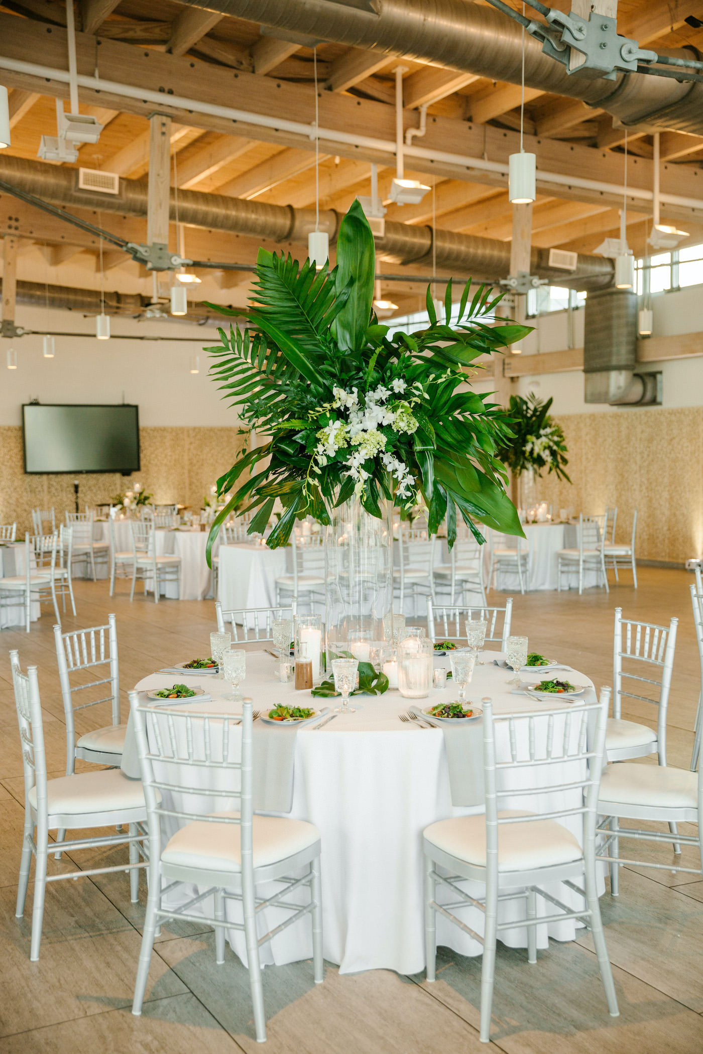 Tropical Tampa Florida Wedding Reception | White Wedding Reception Table with Silver Chiavari Chairs and Tall Tropical Palm Leaf Centerpiece with White Orchids | Tampa Wedding Florist Bruce Wayne Florals