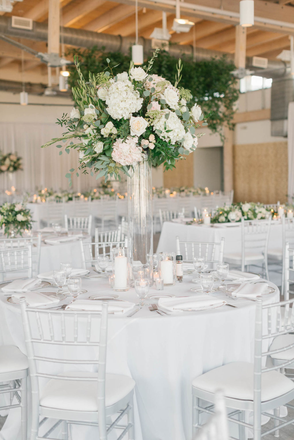 Elegant Boho Chic Wedding Reception Decor, White Linens and Chiavari Chairs, Tall Glass Cylinder Vase with Lush Greenery and White Hydrangeas, Blush Pink Roses Floral Centerpiece | Tampa Bay Wedding Florist Bruce Wayne Florals | Luxury Wedding Planner Parties A'la Carte