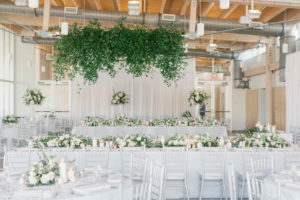 Elegant Boho Chic Wedding Reception Decor, Long Feasting Tables with White Linens, Silver Chiavari Chairs, Lush Floral Centerpieces, Greenery Hanging from Ceiling, Linen Backdrop Drapery | Tampa Wedding Planner Parties A'la Carte | Wedding Drapery Rentals Gabro Event Services | Wedding Florist Bruce Wayne Florals | Catering by the Family