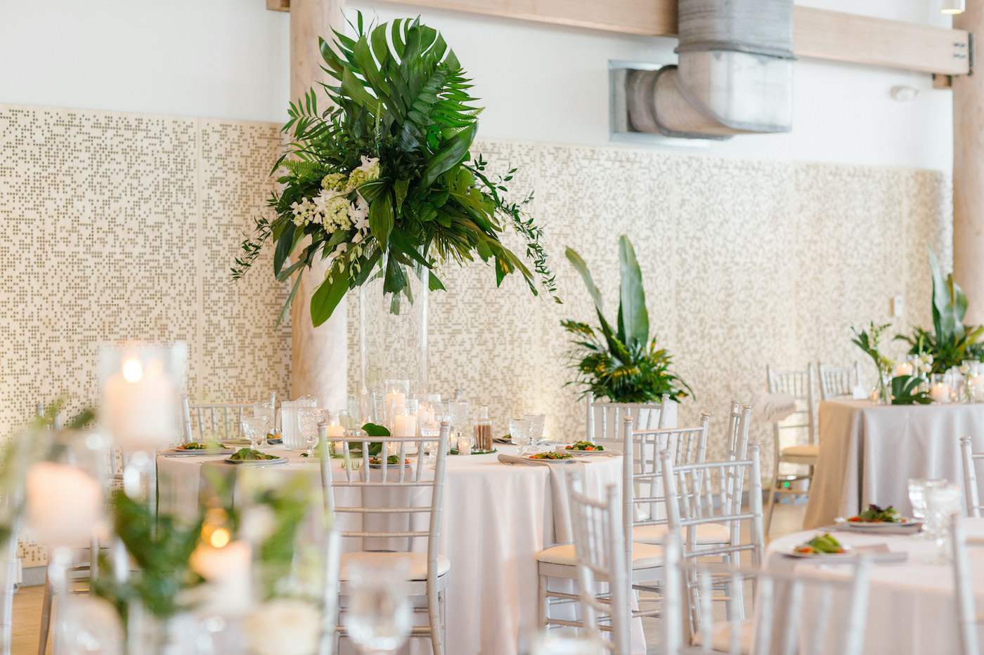 Tropical Tampa Florida Wedding Reception | White Wedding Reception Tables with Silver Chiavari Chairs and Tall Tropical Palm Leaf Centerpiece with White Orchids | Tampa Wedding Florist Bruce Wayne Florals