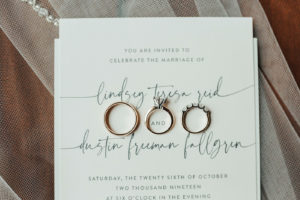 Classic White and Dark Gray Wedding Invitation with Modern Handwritten Font Script, Gold Wedding Bands and Engagement Ring