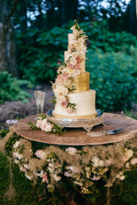 Romantic, Garden Inspired Wedding Cake, 5 Tier Wedding Cake for 200, Gold Icing, Floral Accents with Blush Pink Roses and Ivory Flowers Cascading Down the Cake, Cake Table Decorated with Greenery and Banyan Tree Moss | Florida Wedding Planner NK Weddings
