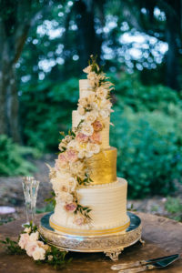 Romantic, Garden Inspired Wedding Cake, 5 Tier Wedding Cake for 200, Gold Icing, Floral Accents with Blush Pink Roses and Ivory Flowers Cascading Down the Cake, Cake Table Decorated with Greenery and Banyan Tree Moss | Florida Wedding Planner NK Weddings