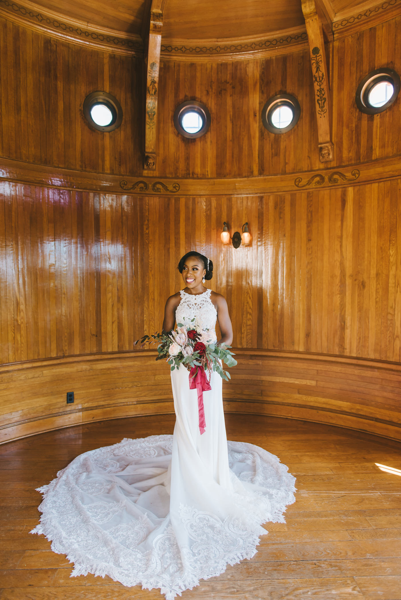 Romantic Florida Bride Holding Luxurious Bridal Bouquet, Bride Wearing Form Fitting Lace Wedding Dress, Holding Red, Pink, Ivory and White Floral Bouquet with Burgundy Ribbon, Inside Historic Powel Crosley Estate in Sarasota | Florida Wedding Photographer Kera Photography