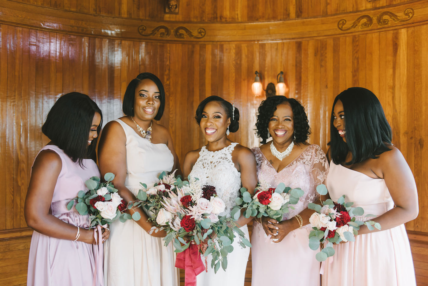 Romantic Florida Bridal Party, Bridesmaids Wearing Mix and Match Pink Color Palette, Holding Luxurious Bridal Bouquet with King Protea, Roses and Eucalyptus Leafs, Bride Wearing Form Fitting Lace Wedding Dress, Holding Red, Pink, Ivory and White Floral Bouquet with Burgundy Ribbon, Inside Historic Powel Crosley Estate in Sarasota | Florida Wedding Photographer Kera Photography