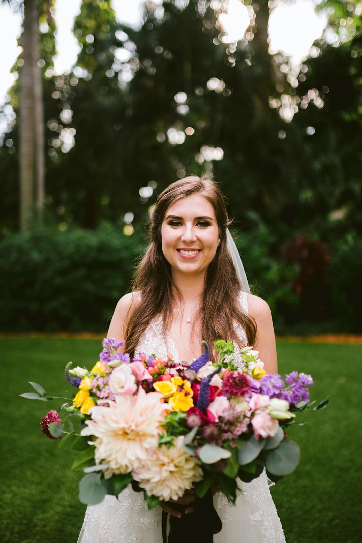 Whimsical Boho Bride Holding Colorful Wild Flower Wedding Bouquet, Pink and Yellow Roses, Blush Dahlia, Purple, Red and White Florals with Greenery Eucalyptus