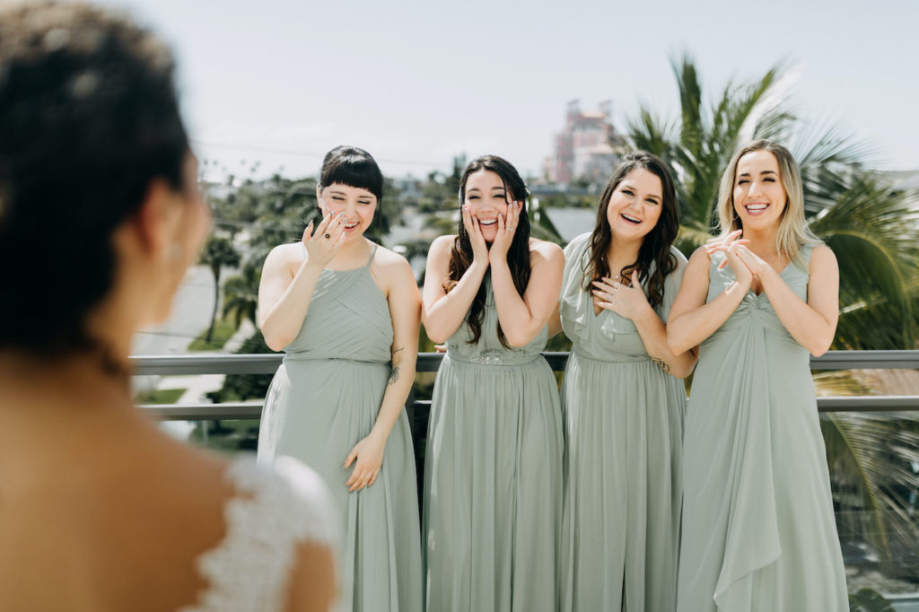 St. Pete Beach Bride and Bridesmaids First Look Portrait, Bridesmaids in Long Mix and Match Sage Green Azazie Dresses | Florida Gulf View Rooftop Wedding Venue The Hotel Zamora | Tampa Bay Hair and Make Up Artist Femme Akoi Beauty Studios