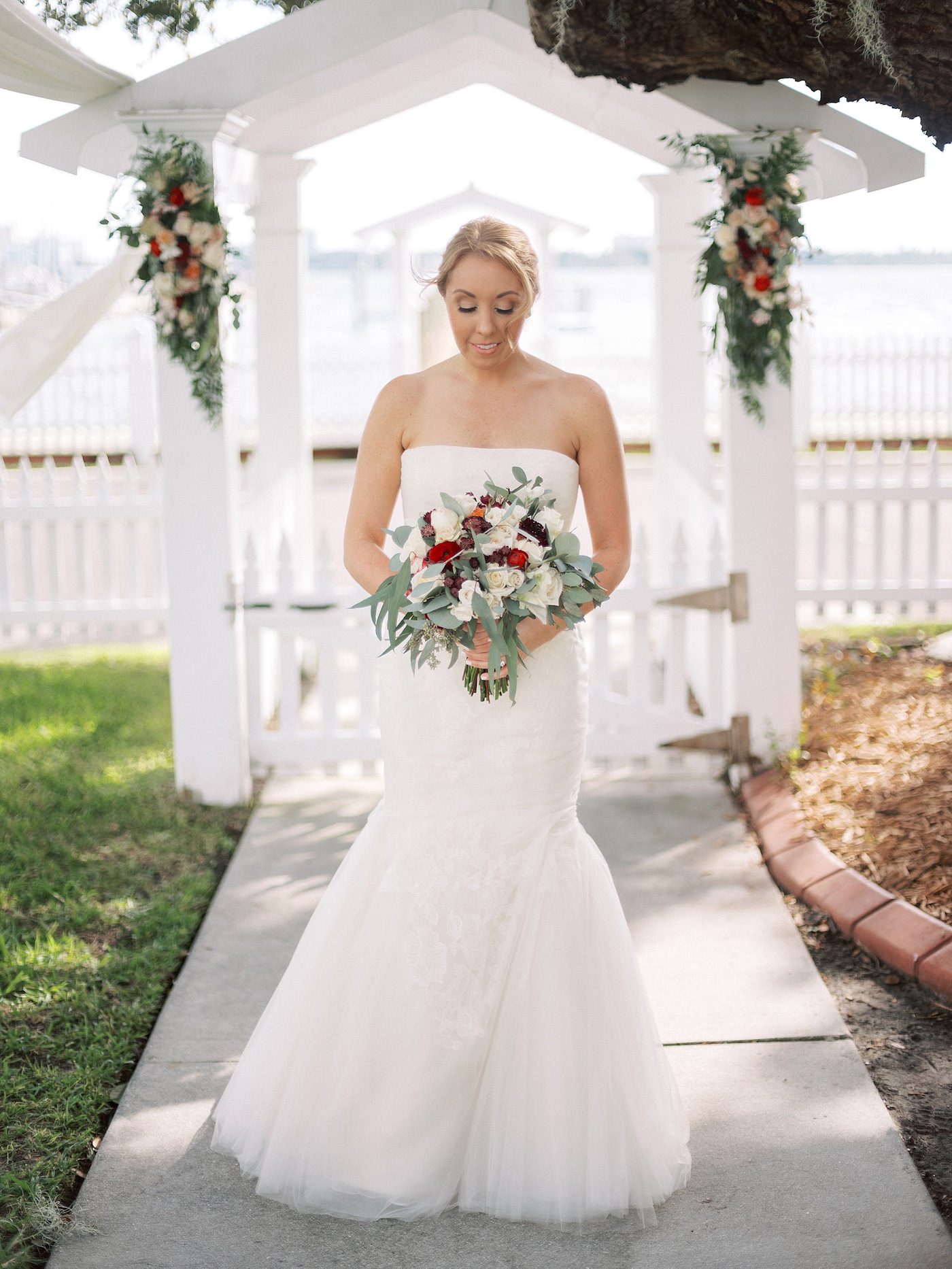 Strapless Ivory Tulle Rouched Mermaid Vera Wang Bridal Gown with Rhinestone Beaded Sash Waistband | Burgundy Wine Bordeaux Red and White Bridal Bouquet with Eucalyptus Greenery by Tampa Wedding Florist Brides N Blooms | Florida Fall Autumn Wedding Waterfront Venue